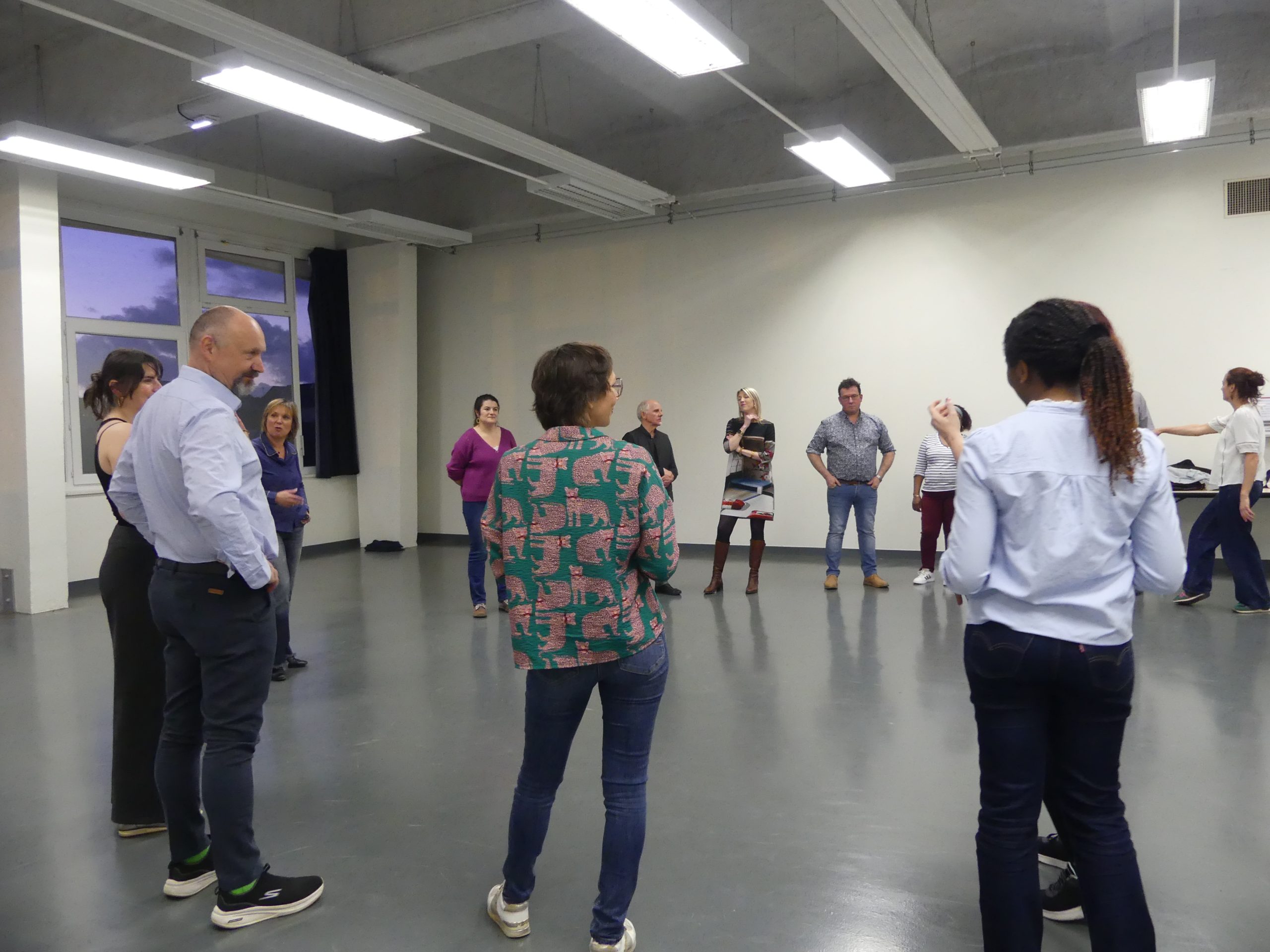 Une classe composée de plusieurs élèves et d'un enseignant, tous engagés dans une discussion interactive.